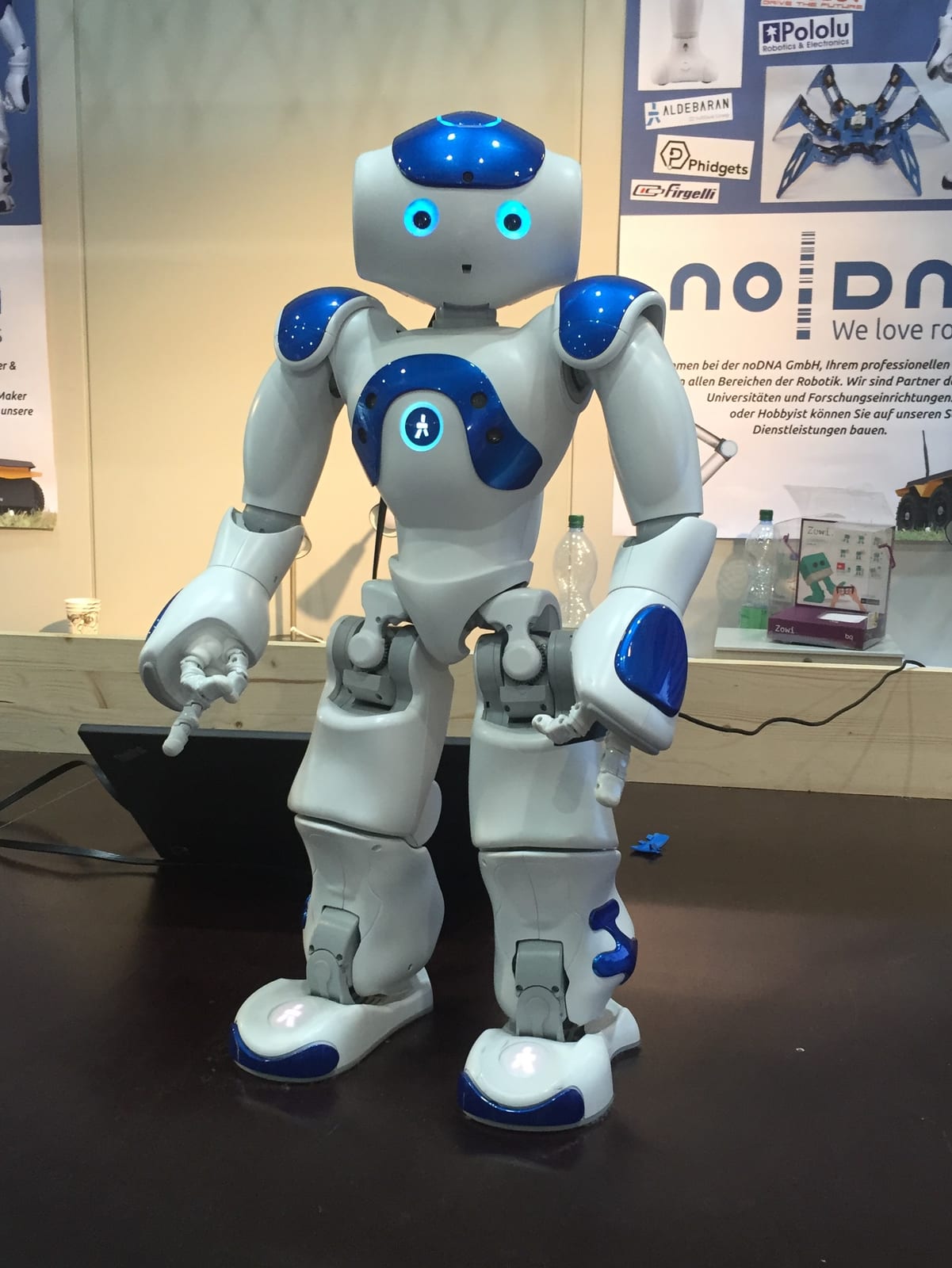 A small white humanoid NAO robot standing on a table